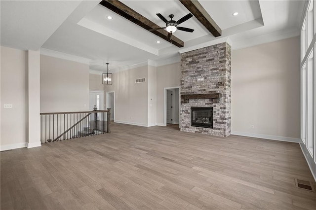 19389 W 114th Ter, Olathe, KS 66061 - unfurnished living room featuring a ceiling fan, light wood finished floors, a fireplace, beamed ceiling, and baseboards