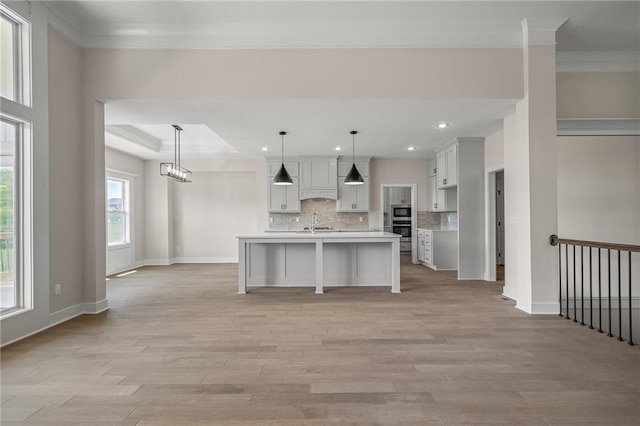 19389 W 114th Ter, Olathe, KS 66061 - kitchen featuring light wood-type flooring, tasteful backsplash, light countertops, ornamental molding, and baseboards
