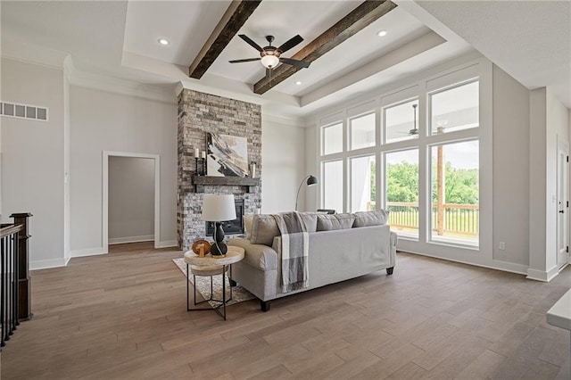 19389 W 114th Ter, Olathe, KS 66061 - living area featuring ceiling fan, beam ceiling, wood finished floors, a fireplace, and a high ceiling