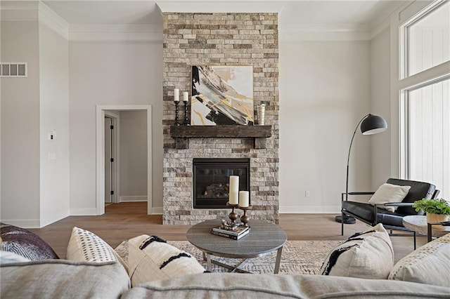 19389 W 114th Ter, Olathe, KS 66061 - living room featuring ornamental molding, wood finished floors, and a large fireplace