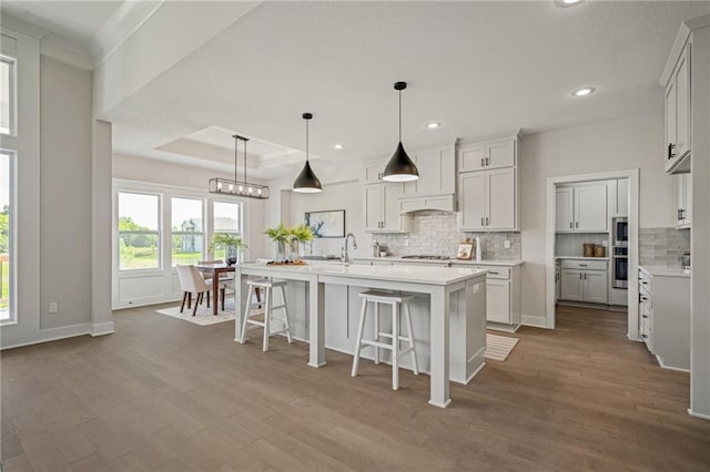 19389 W 114th Ter, Olathe, KS 66061 - kitchen featuring appliances with stainless steel finishes, decorative backsplash, light countertops, recessed lighting, and wood finished floors