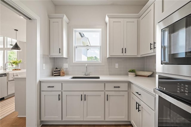 19389 W 114th Ter, Olathe, KS 66061 - kitchen with appliances with stainless steel finishes, decorative backsplash, white cabinetry, and healthy amount of natural light