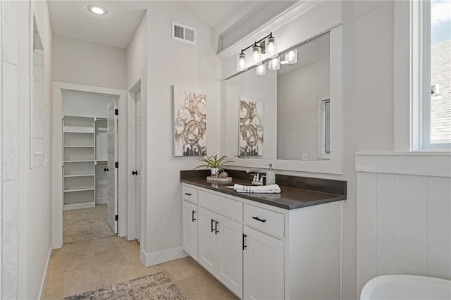19389 W 114th Ter, Olathe, KS 66061 - full bathroom with vanity, a walk in closet, and a freestanding tub