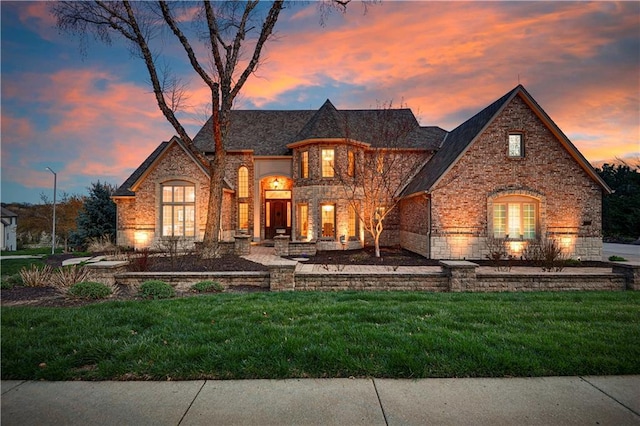 4319 N Mulberry Dr, Kansas City, MO 64116 - french country home featuring brick siding, stone siding, and a lawn