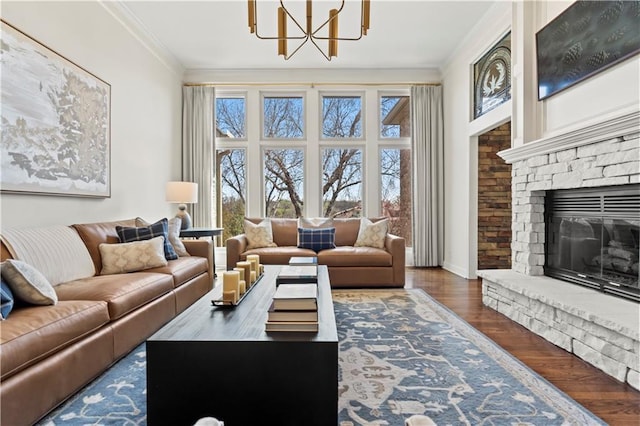 4319 N Mulberry Dr, Kansas City, MO 64116 - living area featuring wood finished floors, ornamental molding, baseboards, a notable chandelier, and a stone fireplace