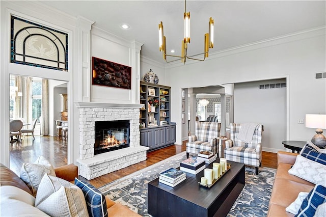 4319 N Mulberry Dr, Kansas City, MO 64116 - living area with an inviting chandelier, wood finished floors, decorative columns, and crown molding