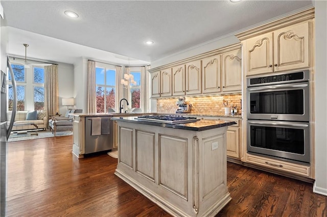 4319 N Mulberry Dr, Kansas City, MO 64116 - kitchen featuring stainless steel appliances, recessed lighting, dark wood-style flooring, cream cabinetry, and a kitchen island