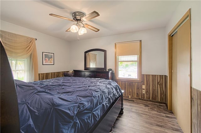 435 NE 41st Ter, Kansas City, MO 64116 - bedroom featuring wood walls, a ceiling fan, wainscoting, and wood finished floors