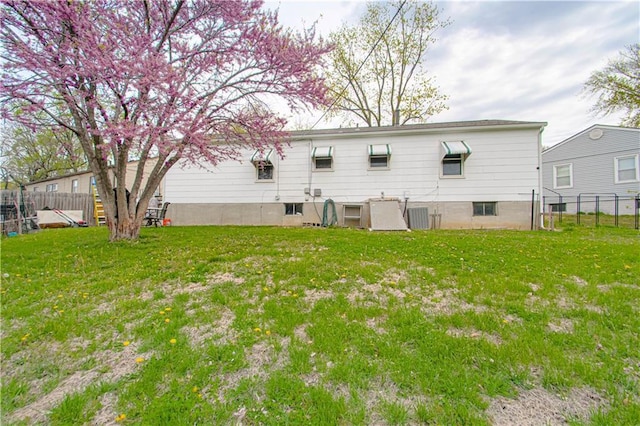 435 NE 41st Ter, Kansas City, MO 64116 - rear view of property with cooling unit, fence, and a lawn