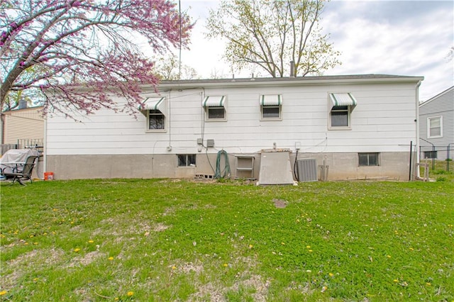 435 NE 41st Ter, Kansas City, MO 64116 - rear view of house with a yard, central air condition unit, and fence