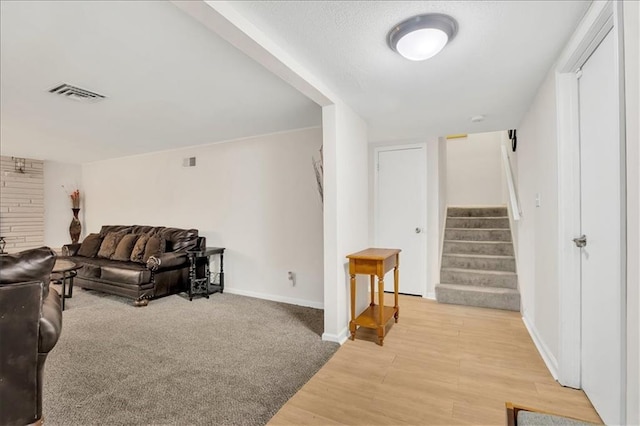 1477 Spruce Ave, Liberty, MO 64068 - living area featuring light wood-style floors, stairs, visible vents, and baseboards