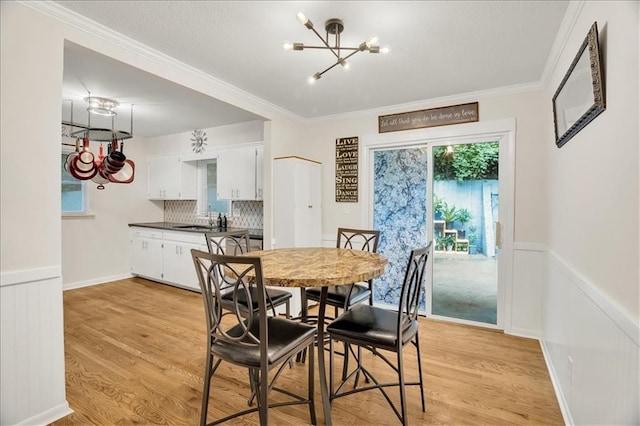 1477 Spruce Ave, Liberty, MO 64068 - dining room featuring light wood-style floors, a notable chandelier, and wainscoting