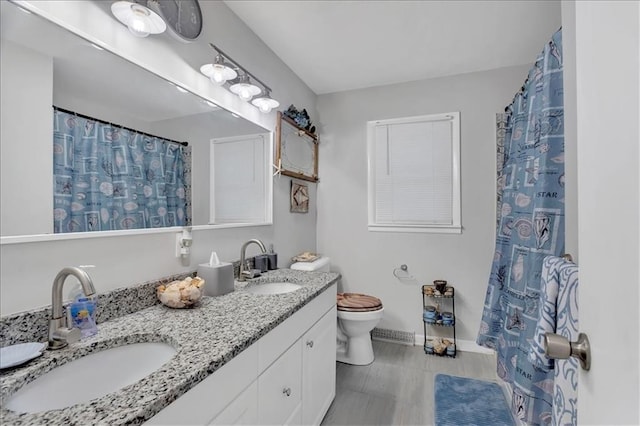 1477 Spruce Ave, Liberty, MO 64068 - full bathroom with a sink, toilet, double vanity, and baseboards