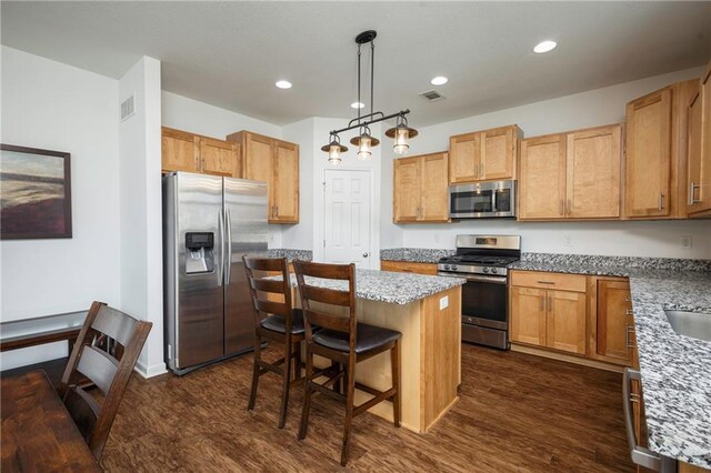 1423 SW Fairfax Rd, Lees Summit, MO 64083 - kitchen featuring appliances with stainless steel finishes, dark wood finished floors, a center island, a kitchen breakfast bar, and recessed lighting
