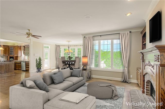 living room featuring baseboards, ornamental molding, a brick fireplace, ceiling fan, and light wood-type flooring