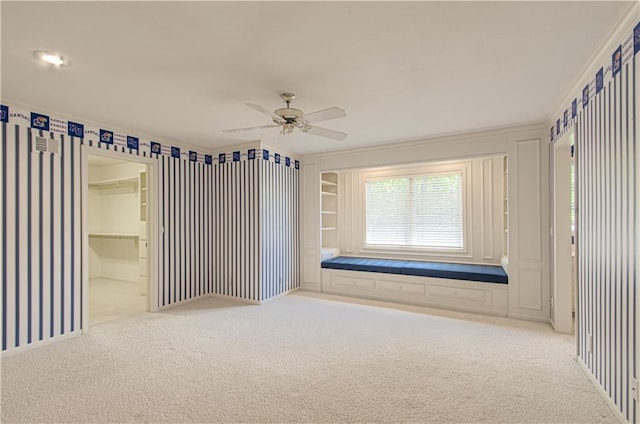 carpeted spare room featuring ornamental molding and ceiling fan