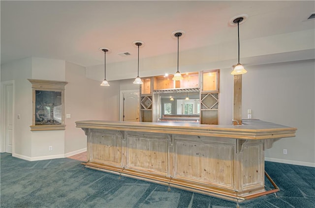indoor bar featuring dark colored carpet, baseboards, and pendant lighting