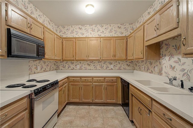 kitchen with black appliances, wallpapered walls, a sink, light countertops, and tasteful backsplash