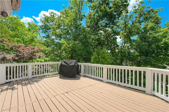 wooden terrace featuring a grill and view of scattered trees