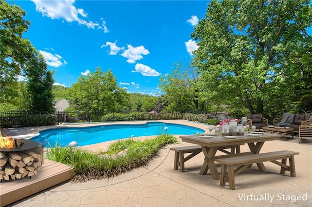view of swimming pool featuring an outdoor fire pit, a fenced backyard, a patio, and view of wooded area