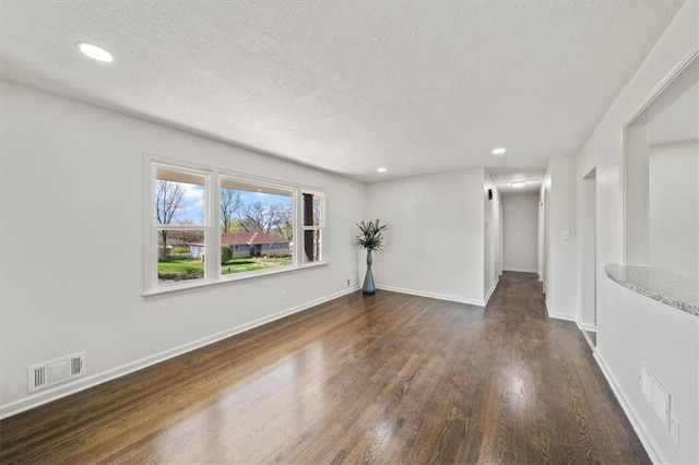 empty room with visible vents, baseboards, recessed lighting, and wood finished floors