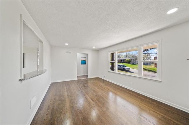 unfurnished living room with baseboards, recessed lighting, a textured ceiling, visible vents, and wood finished floors