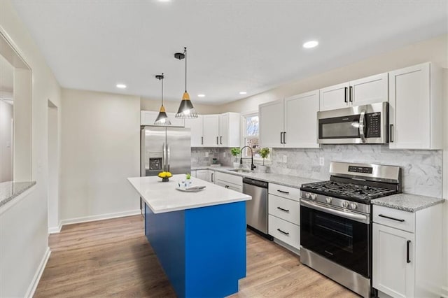 kitchen featuring a sink, white cabinets, appliances with stainless steel finishes, and light wood-style floors
