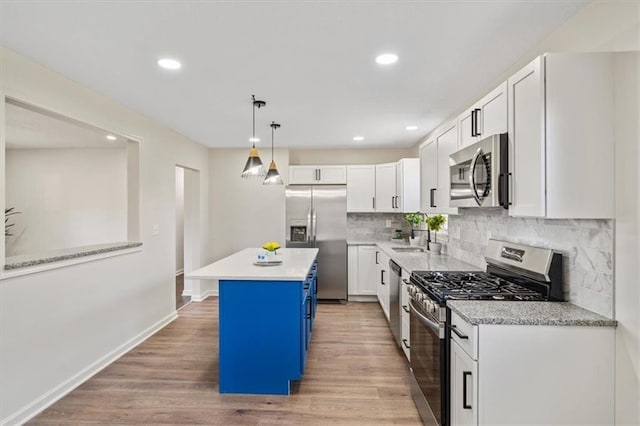 kitchen with light countertops, white cabinets, appliances with stainless steel finishes, and light wood-style floors