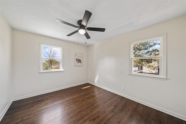 unfurnished room featuring ceiling fan, a textured ceiling, dark wood-style flooring, and baseboards