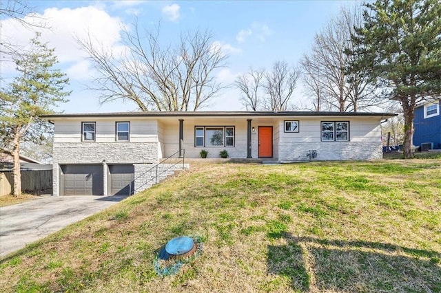 ranch-style house with stone siding, fence, a front lawn, a garage, and driveway