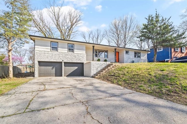 ranch-style home featuring a garage, aphalt driveway, and fence