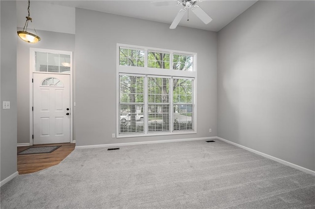 interior space with baseboards, carpet flooring, ceiling fan, and visible vents