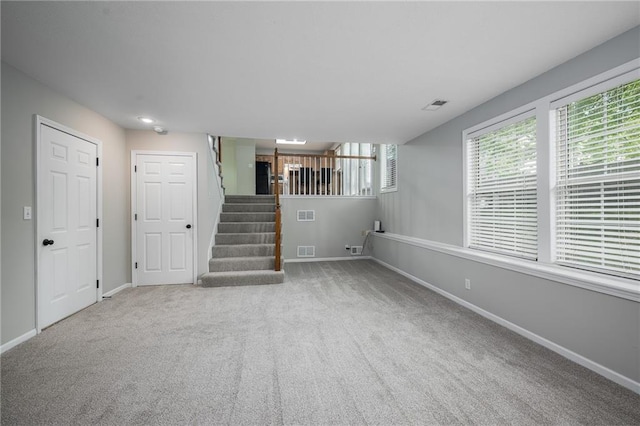 interior space featuring stairs, baseboards, visible vents, and carpet flooring