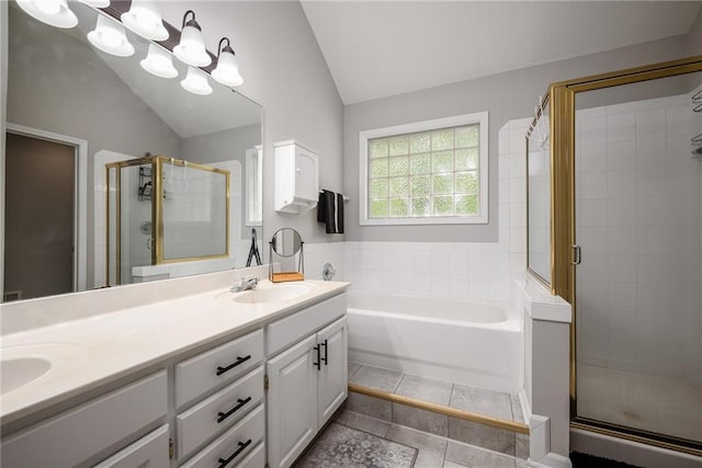 full bathroom with a sink, double vanity, a shower stall, vaulted ceiling, and a garden tub