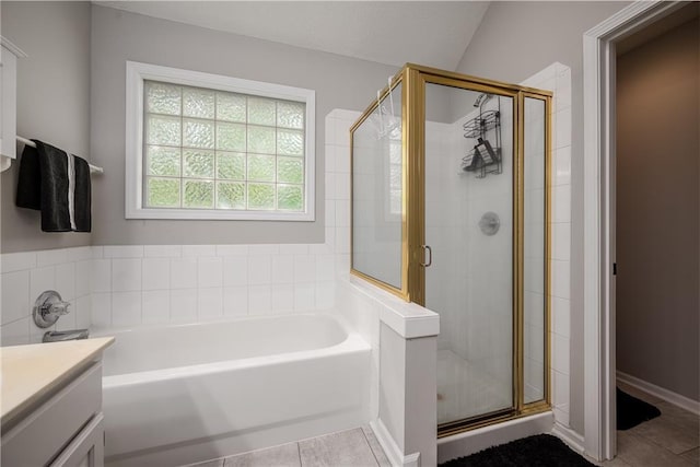 full bathroom featuring tile patterned flooring, a bath, and a stall shower