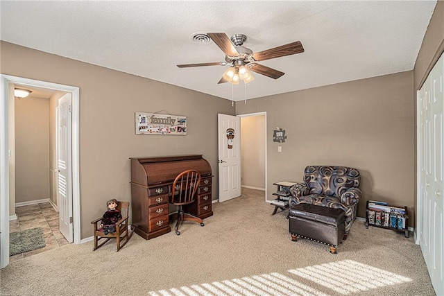 sitting room with a ceiling fan, carpet floors, baseboards, and a textured ceiling