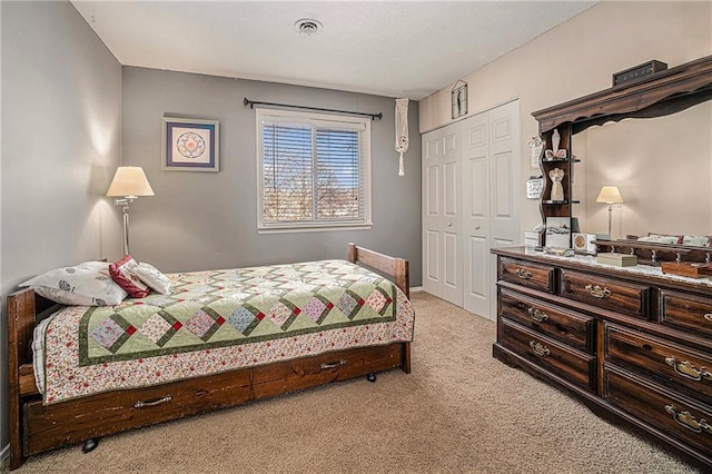 carpeted bedroom featuring a closet and visible vents