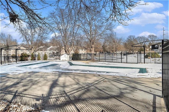 snow covered pool featuring a residential view and fence
