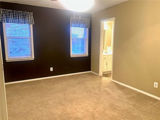 carpeted empty room featuring baseboards