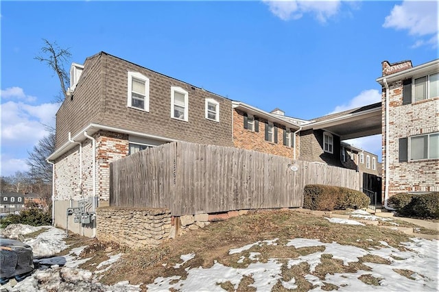 view of property exterior with fence and brick siding