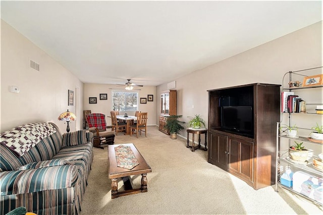 living room featuring light colored carpet, visible vents, and a ceiling fan