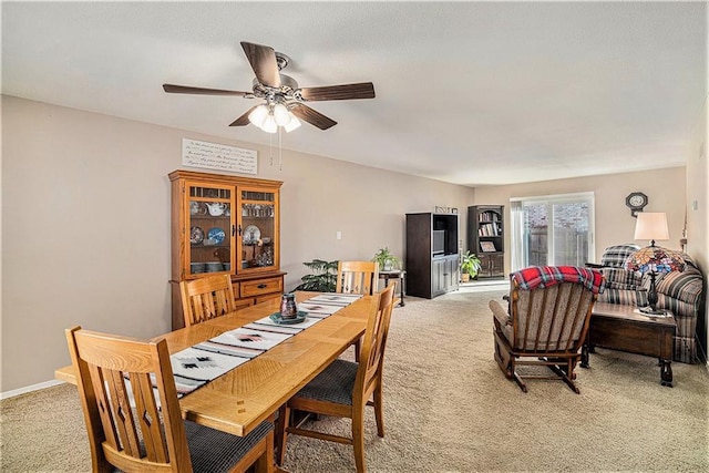 dining space with light carpet, baseboards, and a ceiling fan