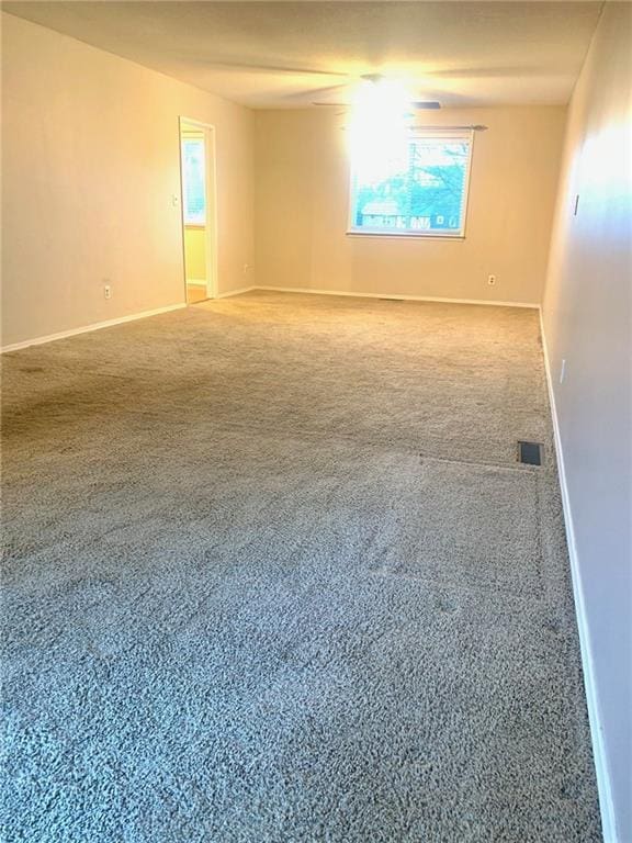 unfurnished room with baseboards, visible vents, and carpet floors