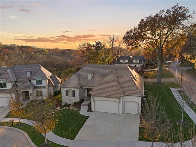 2189 W 89th Pl, Leawood, KS 66206 - view of front of home with a tiled roof, an attached garage, stone siding, stucco siding, and driveway