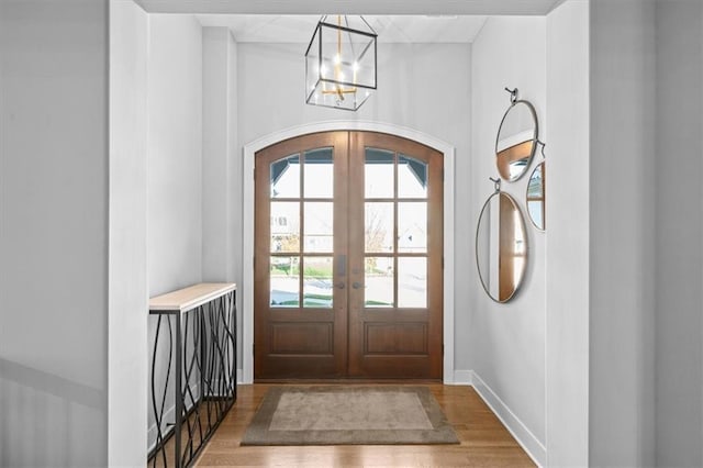 2189 W 89th Pl, Leawood, KS 66206 - entryway featuring baseboards, arched walkways, a chandelier, wood finished floors, and french doors