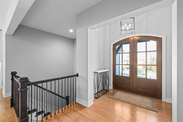 2189 W 89th Pl, Leawood, KS 66206 - entrance foyer with arched walkways, a notable chandelier, recessed lighting, wood finished floors, and french doors