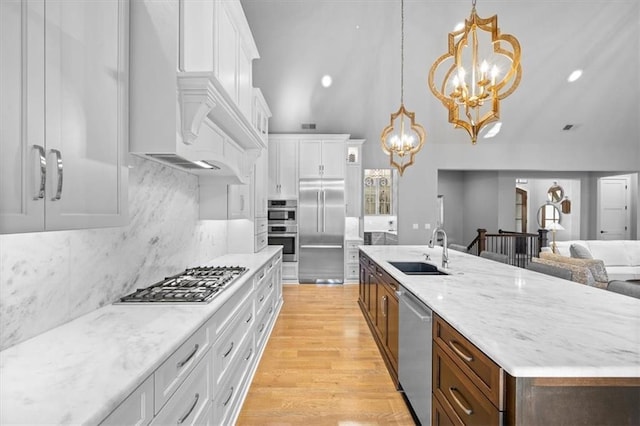 2189 W 89th Pl, Leawood, KS 66206 - kitchen with high vaulted ceiling, an inviting chandelier, white cabinets, stainless steel appliances, and a sink