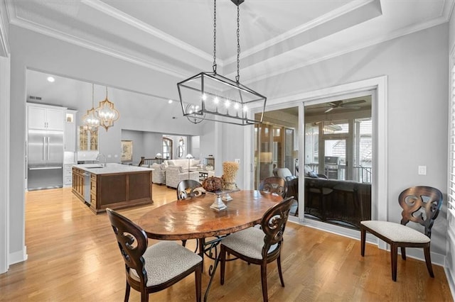 2189 W 89th Pl, Leawood, KS 66206 - dining area featuring light wood-style floors, a tray ceiling, crown molding, and ceiling fan with notable chandelier