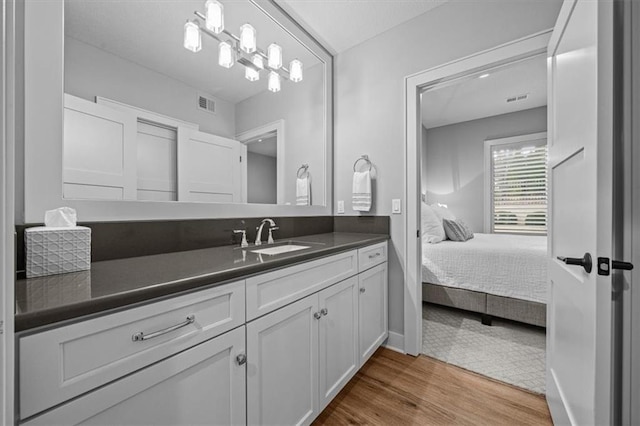 2189 W 89th Pl, Leawood, KS 66206 - ensuite bathroom with visible vents, connected bathroom, vanity, and wood finished floors