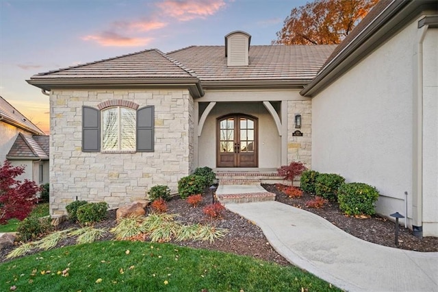 2189 W 89th Pl, Leawood, KS 66206 - property entrance featuring stone siding, a tile roof, french doors, and stucco siding